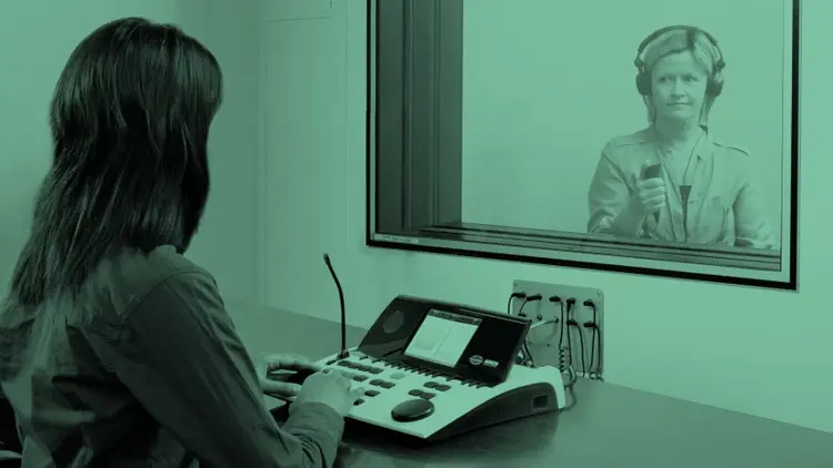 Patient seated in a soundbooth during a hearing test