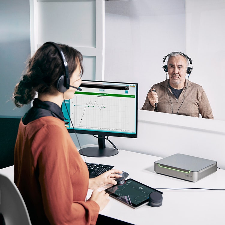 Clinician performing the Audible Contrast Threshold (ACT™) test on a patient using the Equinox Evo clinical audiometer paired with the Touch Keyboard.