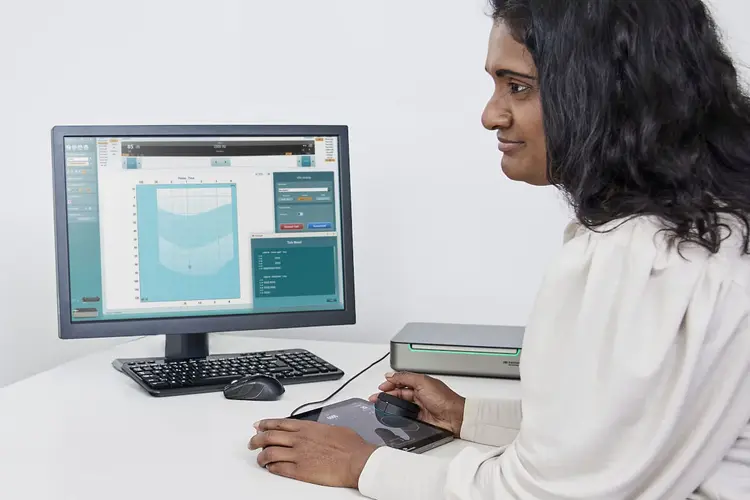 An audiologist is looking at her screen that displays the Automated ticksheet available with the Equinox Evo pediatric module