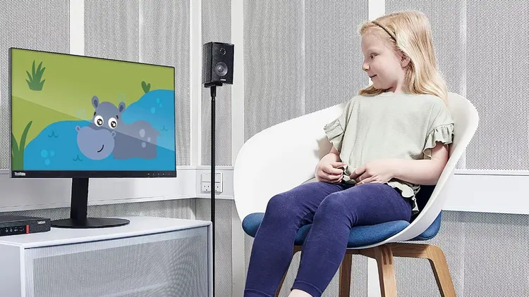 Girl looking at animation of hippo on computer screen