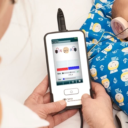 Person holding the Sera while performing hearing screening in sleeping baby