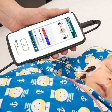 Person holding the Sera while performing hearing screening in sleeping baby
